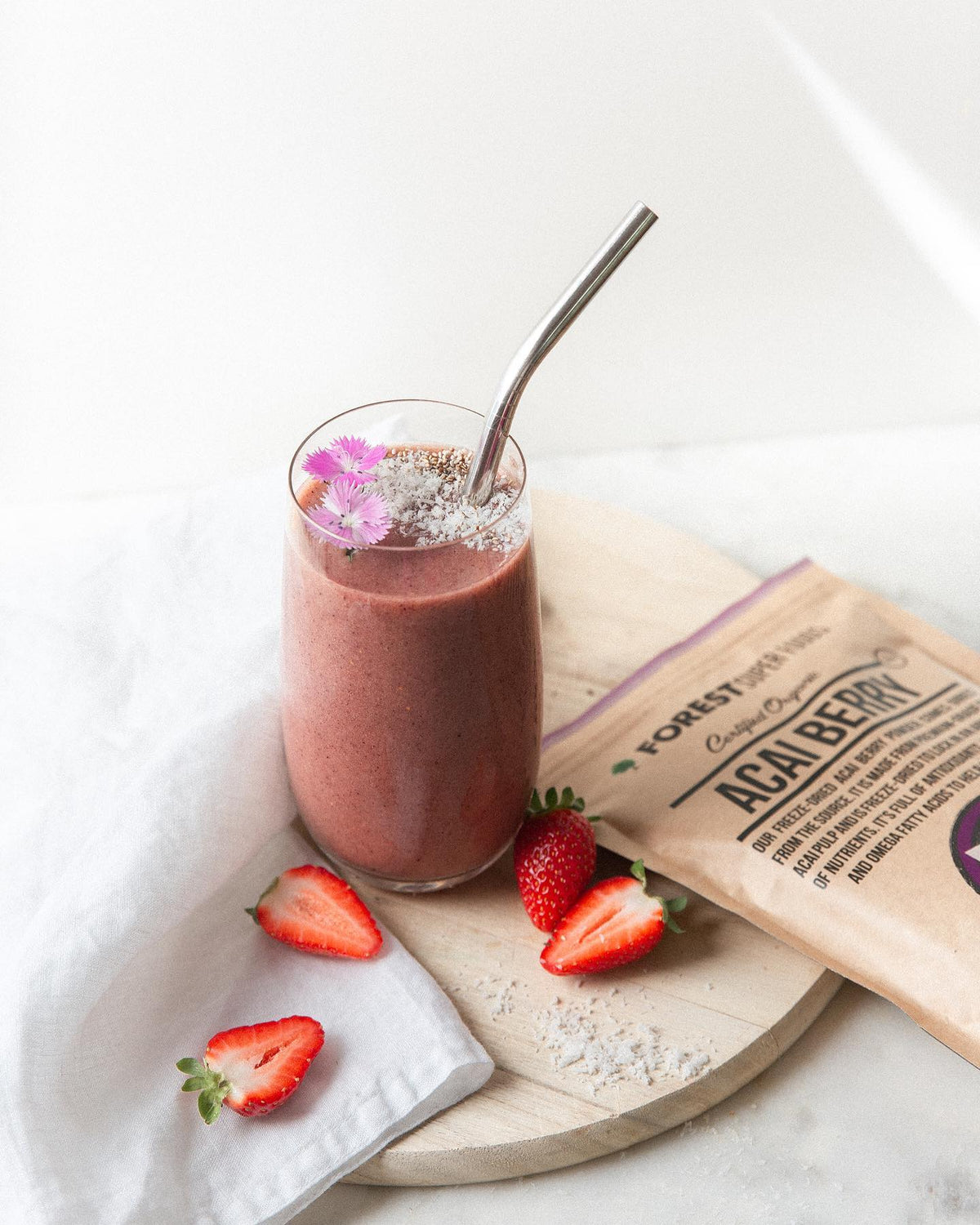 Certified Organic Acai Berry Powder with smoothie in glass, fresh strawberries, and natural superfood ingredients by Forest Super Foods