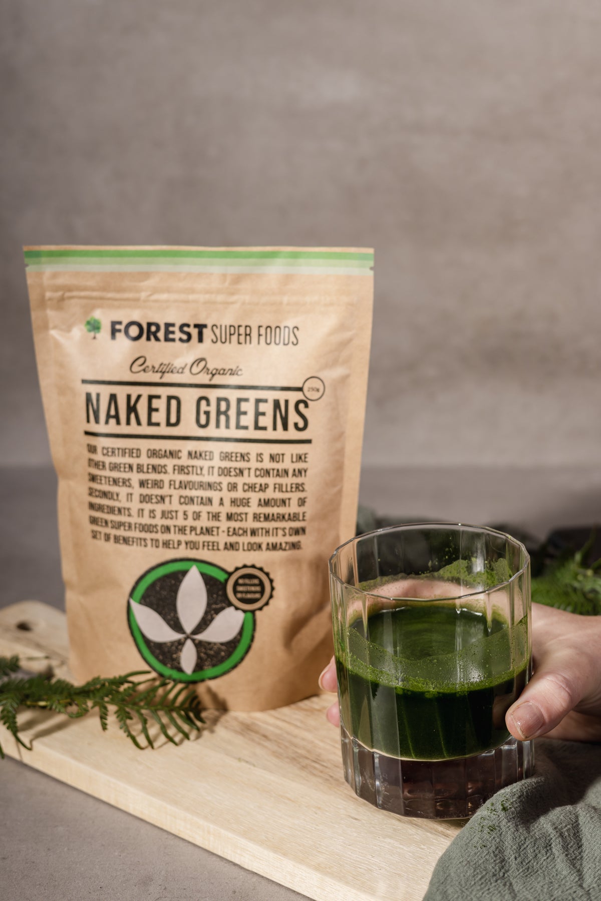 Mini Australian Greens Powder by Forest Super Foods with organic whole food blend in resealable pouch and green drink glass